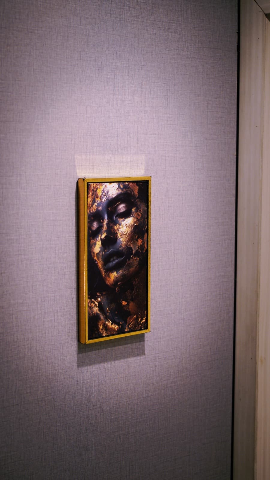 Gold-framed wall art with abstract face